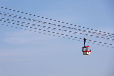 Low angle view of overhead cable car against sky