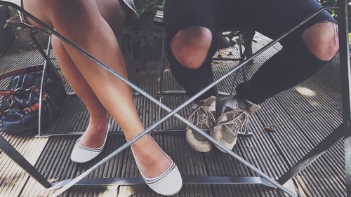 Low section of man and woman standing on escalator