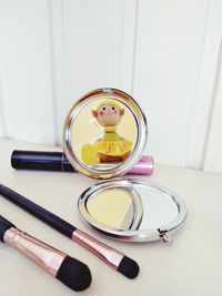 Close-up of beauty product and hand mirror on table