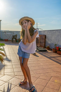 Full length portrait of beautiful woman against sky