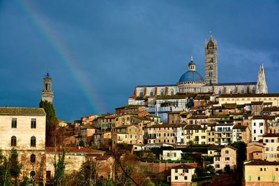 Low angle view of siena cathedral and town against blue sky