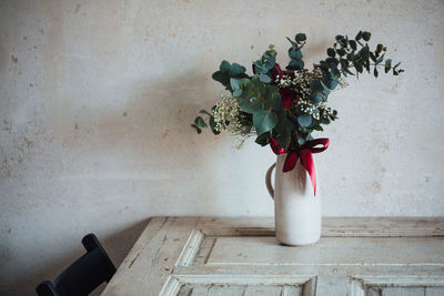 Close-up of vase with bunch of flowers on table