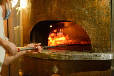 Pizza maker cooking pizzas in wood oven