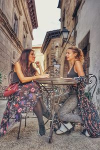 Full length of woman sitting outside building