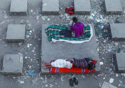 High angle view of people sitting on street in city