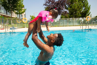 Rear view of woman jumping in swimming pool