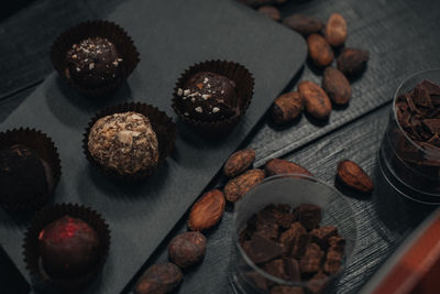 Handmade chocolate raw candies on dark wooden rustic background with cacao beans. dark chocolate