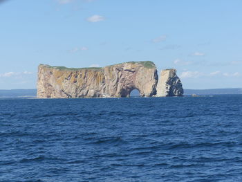 Rock formations by sea against sky