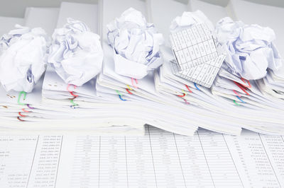 High angle view of crumpled paper balls and model house on financial documents