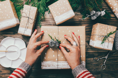 High angle view of woman holding christmas decoration on table