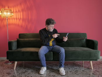 Young man sitting on sofa at home