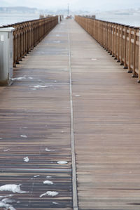 Surface level of wooden walkway against sky