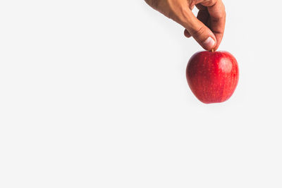 Hand holding apple against white background