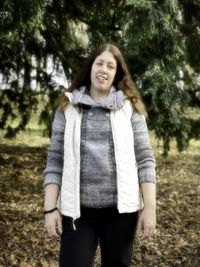 Portrait of smiling young woman standing on land