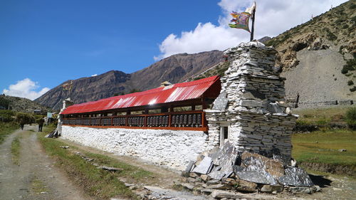 Built structure by mountain against sky