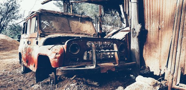 Old abandoned car on field