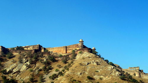 Low angle view of castle against clear blue sky