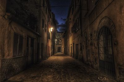 Narrow walkway along buildings at night