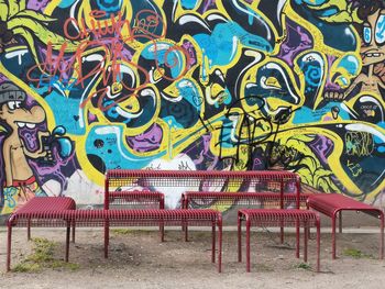 Empty bench against graffiti wall