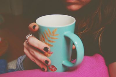 Low section of woman holding coffee cup