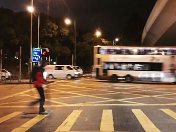 Man on car moving on illuminated city at night