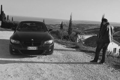 Rear view of man standing on road against sky