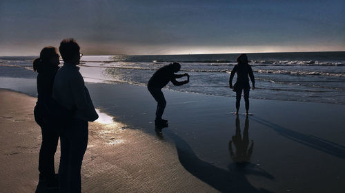 People at beach against sky