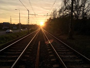 Railroad tracks against sky during sunset