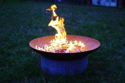 Close-up of burning candles on field