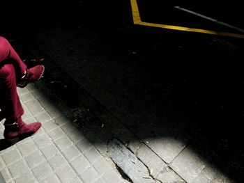 Low section of woman with umbrella at night