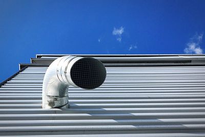 Low angle view of pipe on building against sky