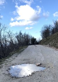 Road amidst trees against sky