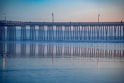 Pier over sea against sky at sunset