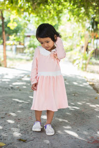 Cute girl standing on footpath