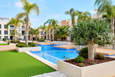 Swimming pool by building against blue sky