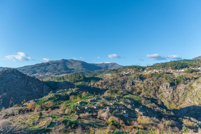 Scenic view of mountains against blue sky