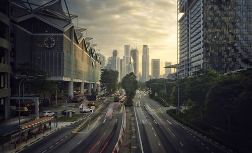 Traffic on city street by buildings against sky