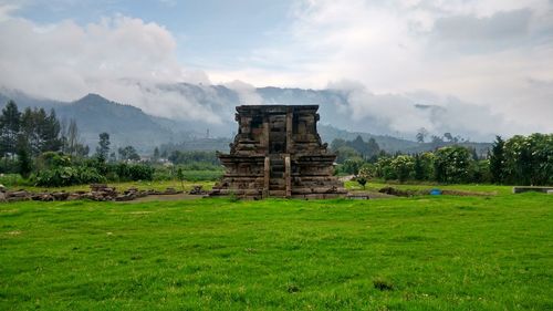 Built structure on field against sky