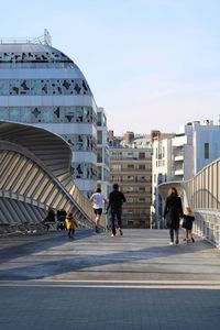 Rear view of people walking on building