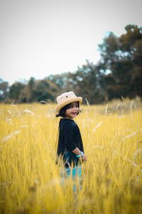 Side view of girl standing on grassy field