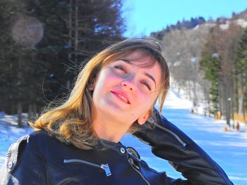 Close-up portrait of young woman standing in snow