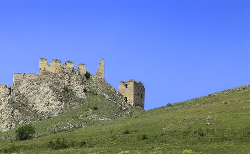 Low angle view of old building against clear blue sky