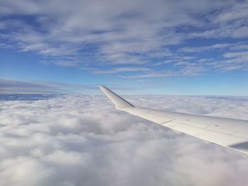 View of airplane wing over clouds
