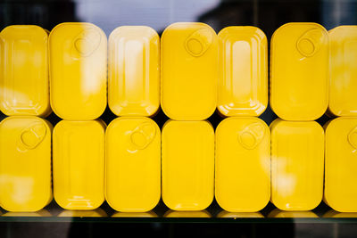 Close-up of yellow containers seen from glass