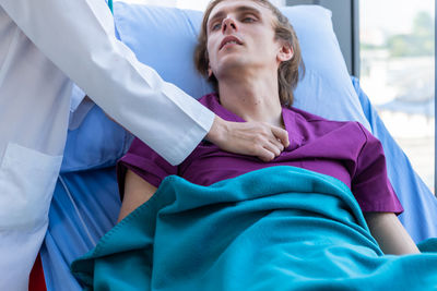 Portrait of doctor examining patient in hospital