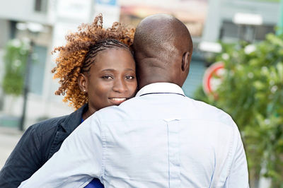 This young couple embraces on the street and happy.