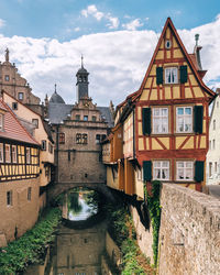 Canal amidst buildings in town against sky