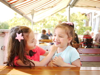 Portrait of smiling girl sitting on table