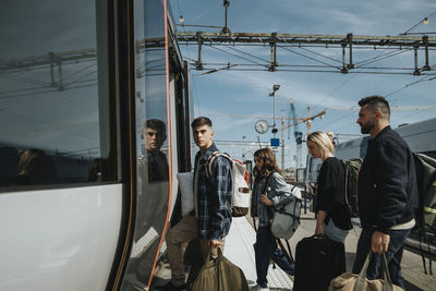 Family with luggage entering in train at station