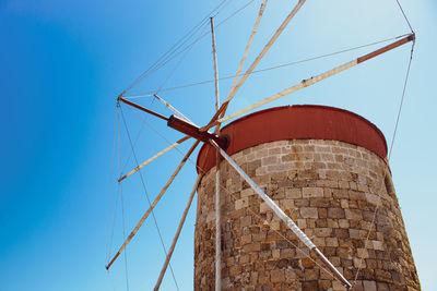 Low angle view of traditional windmill against clear blue sky
